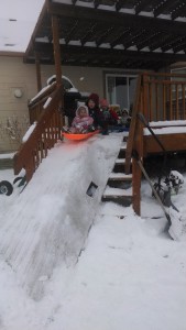 Kids sledding off the deck